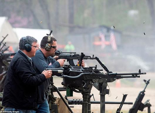 Two men wear ear defenders while they fire machine guns on the main firing line on the weekend. The bottom gun pictured appears to be an M2 Browning, with more modern guns firing above