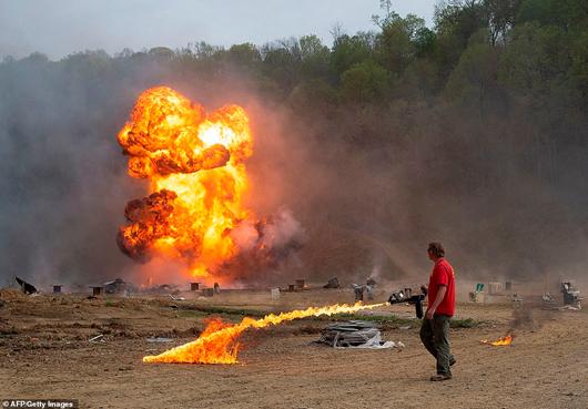 An employee uses a flame thrower as an explosion goes off during a shooting session. At old meet ups, visitors used to be able to rent a flame thrower to use, but now they are handled by a select few. Machine gun owners can reserve spots on the main firing line, but the waiting list is up to 10 years. On a secondary firing line other vendors rent out machine guns to anyone willing to pay for a few rounds