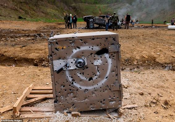 The power of the artillery on show is demonstrated by a safe - featuring a smiley face - being riddled with bullet holes on the main firing line. It once sat on a wooden pallet, but that was destroyed by the bullets. Behind it, a group of men assess the damage done to a raised car